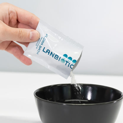Ein Sachet Flora Bath wird in eine schwarze Schüssel geschüttet